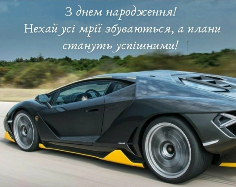 Чорний спорткар на дорозі з привітанням з днем народження українською.
